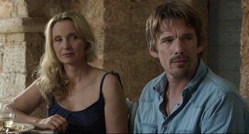Movie still from “Before Midnight” (2013), directed by Richard Linklater – A man and a woman standing next to each other in front of a brick wall; Close Up shot, Over the shoulder angle