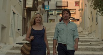 Movie still from “Before Midnight” (2013), directed by Richard Linklater – A man and a woman walking down a street; Medium shot, Low angle