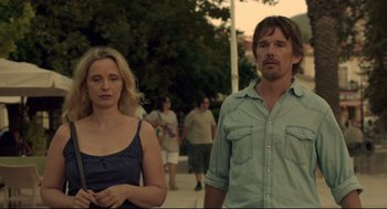 Movie still from “Before Midnight” (2013), directed by Richard Linklater – A man and a woman standing next to each other on a sidewalk; Medium shot, Low angle