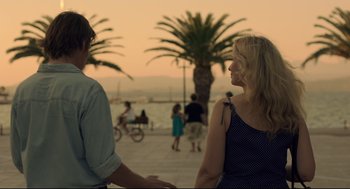 Movie still from “Before Midnight” (2013), directed by Richard Linklater – Two people standing next to each other on a sidewalk; Medium shot, Over the shoulder angle