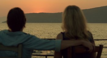 Movie still from “Before Midnight” (2013), directed by Richard Linklater – Two people sitting on a bench looking out at the ocean; Medium shot, Low angle