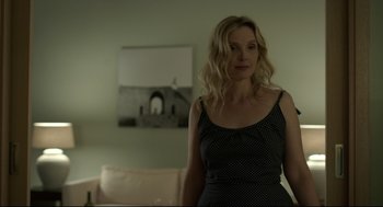 Movie still from “Before Midnight” (2013), directed by Richard Linklater – A woman standing in front of a mirror in a living room; Medium shot, Over the shoulder angle