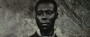 Movie still from “Small Axe” (2020), directed by Steve McQueen – An old black and white photo of a man; Extreme Close Up shot, High angle