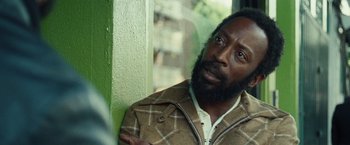 Movie still from “Small Axe” (2020), directed by Steve McQueen – A man with a beard is looking at the camera; Close Up shot, Over the shoulder angle