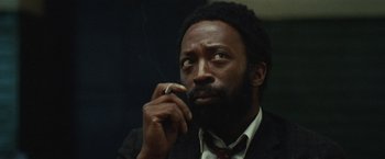 Movie still from “Small Axe” (2020), directed by Steve McQueen – A person talking on a cell phone; Close Up shot, Low angle