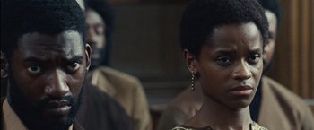 Movie still from “Small Axe” (2020), directed by Steve McQueen – A woman sitting next to a man in a room; Close Up shot, Over the shoulder angle