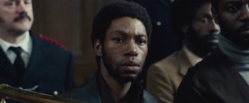 Movie still from “Small Axe” (2020), directed by Steve McQueen – A person wearing a suit and tie; Close Up shot, Low angle