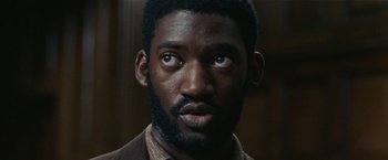 Movie still from “Small Axe” (2020), directed by Steve McQueen – A person with a beard looking at the camera; Close Up shot, Low angle