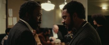 Movie still from “Small Axe” (2020), directed by Steve McQueen – Two men talking to each other in a restaurant; Close Up shot, Over the shoulder angle