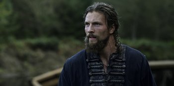 Movie still from “Vikings: Valhalla” (2022), created by Jeb Stuart – A man with long hair and a long beard; Close Up shot, Low angle