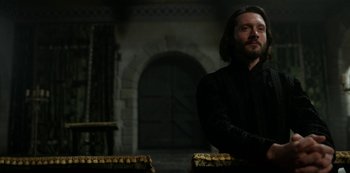 Movie still from “Vikings: Valhalla” (2022), created by Jeb Stuart – A man sitting in front of an archway in a room; Medium shot, Low angle