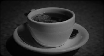 Movie still from “What Did Jack Do?” (2017), directed by David Lynch – Black and white photograph of a cup of coffee on a saucer; Extreme Close Up shot, High angle