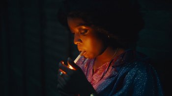 Movie still from “Small Axe” (2020), directed by Steve McQueen – A woman is lighting a cigarette in the dark; Close Up shot, High angle