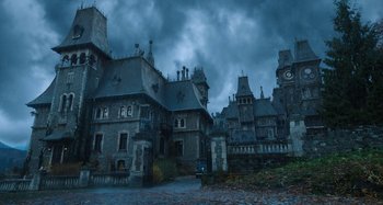 Movie still from “Wednesday” (2022), created by Miles Millar – An image of an old building in the middle of the night; Extreme Wide shot, Low angle