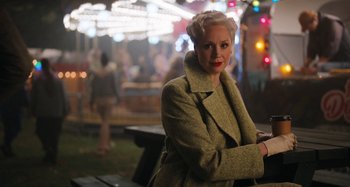 Movie still from “Wednesday” (2022), created by Miles Millar – A woman with blonde hair wearing a green coat; Medium shot, Over the shoulder angle