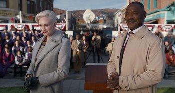 Movie still from “Wednesday” (2022), created by Miles Millar – A man and a woman standing next to each other; Medium shot, Over the shoulder angle