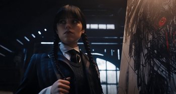 Movie still from “Wednesday” (2022), created by Miles Millar – A young girl in a school uniform with pigtails; Close Up shot, Low angle