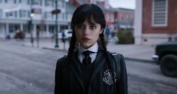 Movie still from “Wednesday” (2022), created by Miles Millar – A young woman in a school uniform with pigtails; Close Up shot, Low angle