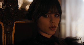 Movie still from “Wednesday” (2022), created by Miles Millar – A person wearing a black shirt; Close Up shot, Over the shoulder angle