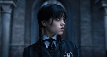 Movie still from “Wednesday” (2022), created by Miles Millar – A young girl in a school uniform with plaited hair; Close Up shot, High angle