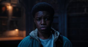 Movie still from “Wednesday” (2022), created by Miles Millar – A young man in a hooded jacket looking at the camera; Close Up shot, Low angle