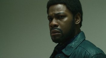 Movie still from “Small Axe” (2020), directed by Steve McQueen – A person wearing a jacket; Close Up shot, Low angle