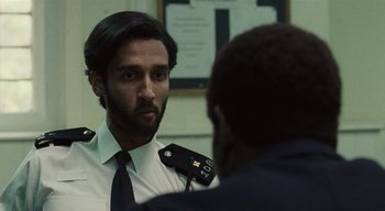 Movie still from “Small Axe” (2020), directed by Steve McQueen – A man in a suit and tie talking to another man in a suit and tie; Close Up shot, Over the shoulder angle