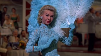 Movie still from “White Christmas” (1954), directed by Michael Curtiz – A woman in a blue dress holding an umbrella; Medium shot, Low angle