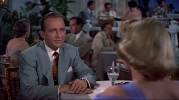 Movie still from “White Christmas” (1954), directed by Michael Curtiz – A man and a woman sitting at a table in a restaurant; Medium shot, Over the shoulder angle