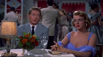 Movie still from “White Christmas” (1954), directed by Michael Curtiz – A man and a woman sitting at a dinner table; Medium shot, Over the shoulder angle