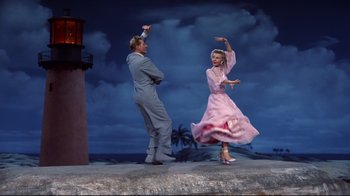 Movie still from “White Christmas” (1954), directed by Michael Curtiz – A man and a woman dancing on a stage; Wide shot, Low angle