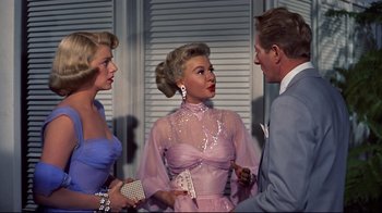 Movie still from “White Christmas” (1954), directed by Michael Curtiz – Two women and a man standing next to each other; Medium shot, Over the shoulder angle