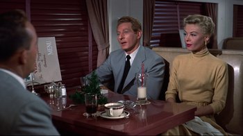 Movie still from “White Christmas” (1954), directed by Michael Curtiz – A man and a woman sitting at a dinner table; Medium shot, High angle