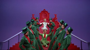 Movie still from “White Christmas” (1954), directed by Michael Curtiz – A group of men dressed in green and green hats; Wide shot, Low angle