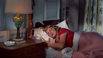 Movie still from “White Christmas” (1954), directed by Michael Curtiz – A young girl sleeping in a bed next to a nightstand; Medium shot, Overhead angle