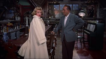 Movie still from “White Christmas” (1954), directed by Michael Curtiz – A man and a woman standing next to each other in a room; Medium shot, Over the shoulder angle