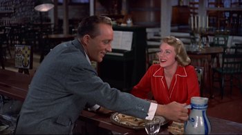 Movie still from “White Christmas” (1954), directed by Michael Curtiz – A man and a woman sitting at a table; Medium shot, Low angle