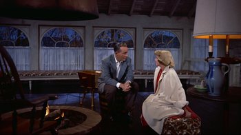 Movie still from “White Christmas” (1954), directed by Michael Curtiz – A man and a woman sitting in front of a fire pit; Medium shot, Over the shoulder angle