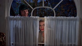 Movie still from “White Christmas” (1954), directed by Michael Curtiz – A man and a woman peeking through a window; Medium shot, Low angle