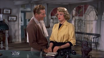 Movie still from “White Christmas” (1954), directed by Michael Curtiz – A man and a woman standing next to each other at a table; Medium shot, Over the shoulder angle