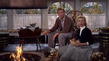Movie still from “White Christmas” (1954), directed by Michael Curtiz – A man and a woman sitting in a rocking chair; Medium shot, High angle