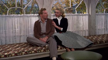 Movie still from “White Christmas” (1954), directed by Michael Curtiz – A man and a woman sitting on a couch; Medium shot, Low angle