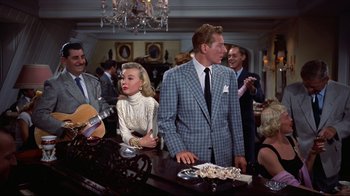 Movie still from “White Christmas” (1954), directed by Michael Curtiz – A group of people standing in a room; Medium shot, Over the shoulder angle