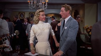 Movie still from “White Christmas” (1954), directed by Michael Curtiz – A man and a woman standing next to each other in a room; Medium shot, Over the shoulder angle