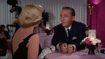 Movie still from “White Christmas” (1954), directed by Michael Curtiz – A man and a woman are sitting at a table talking; Medium shot, Over the shoulder angle