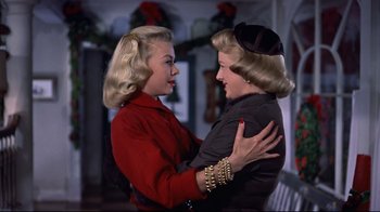 Movie still from “White Christmas” (1954), directed by Michael Curtiz – Two women are embracing each other in a room; Medium shot, Low angle