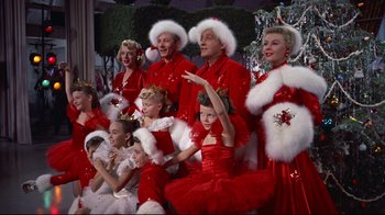 Movie still from “White Christmas” (1954), directed by Michael Curtiz – A group of people dressed up in red and white outfits; Medium shot, Low angle