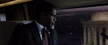 Movie still from “White House Down” (2013), directed by Roland Emmerich – A man in a suit and tie looking out of a window; Close Up shot, Over the shoulder angle