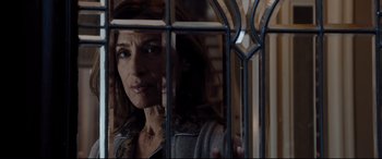 Movie still from “White House Down” (2013), directed by Roland Emmerich – A woman standing behind bars looking out of a window; Close Up shot, Over the shoulder angle