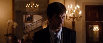 Movie still from “White House Down” (2013), directed by Roland Emmerich – A man in a suit and tie standing in front of a chandelier; Close Up shot, Over the shoulder angle